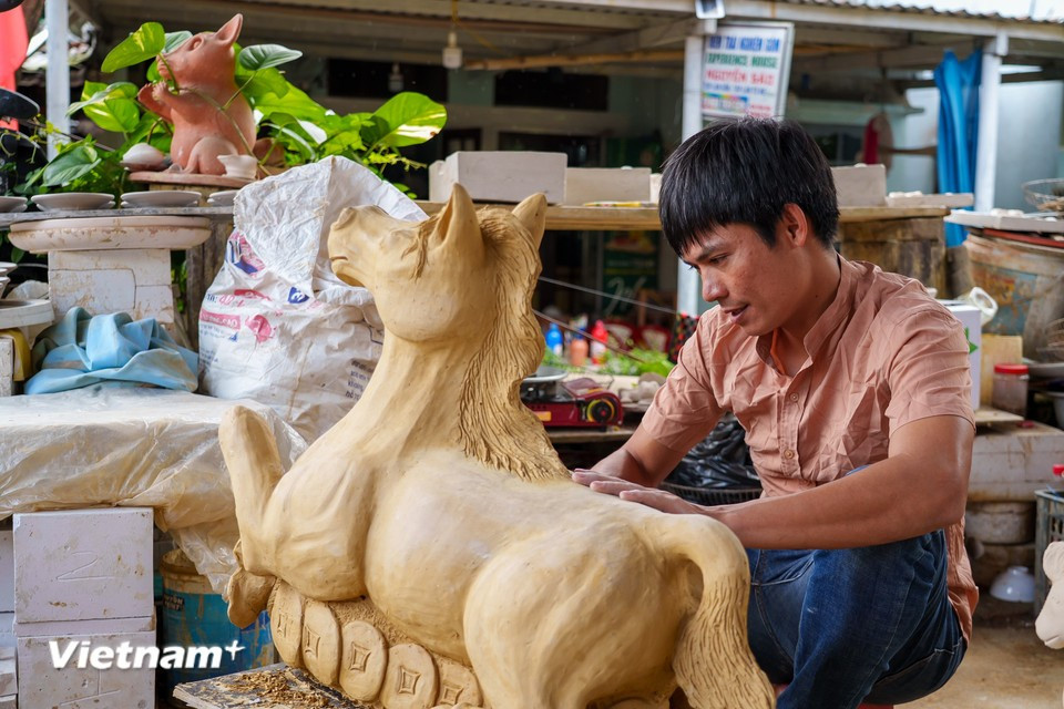 L’effervescence du Têt gagne les ateliers : le jeune artisan Le Van Nhat apporte les touches finales à une figurine de cheval chargée de lingots d’or, symbole de prospérité et de réussite pour la nouvelle année. Photo : Vietnam+