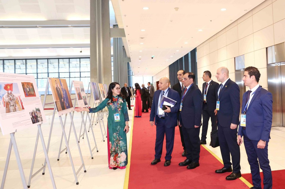 Des délégués internationaux visite l'exposition de photos de l'Agence vietnamienne d'Information lors de la cérémonie d'ouverture à la signature de la Convention de Hanoï le 25 octobre. Photo: VNA
