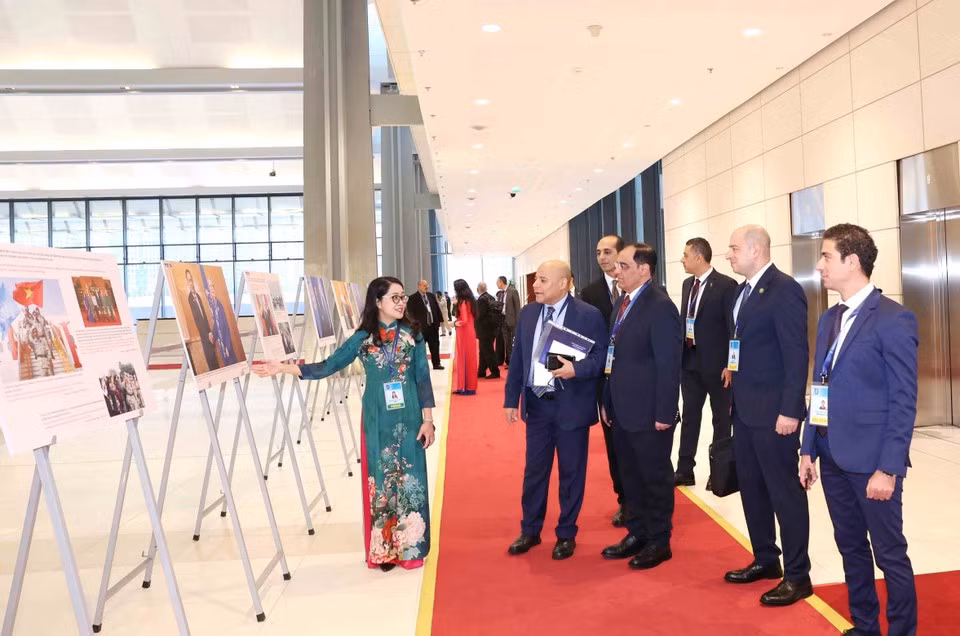 Des délégués internationaux visite l'exposition de photos de l'Agence vietnamienne d'Information lors de la cérémonie d'ouverture à la signature de la Convention de Hanoï le 25 octobre. Photo: VNA