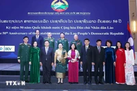 Des responsables vietnamiens et lao au banquet en l'honneur du 50ᵉ anniversaire de la Fête nationale du Laos. Photo: VNA