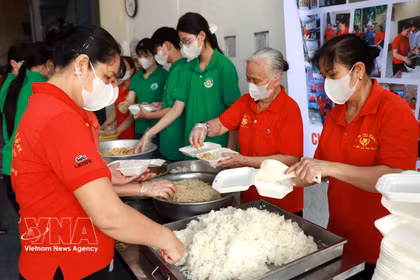 Des membres de l'Association des bénévoles pour les repas (quartier de Thien Truong) et des élèves du lycée Nguyen Khuyen (quartier de Nam Dinh) préparent des repas gratuits destinés aux patients. Photo : VNA