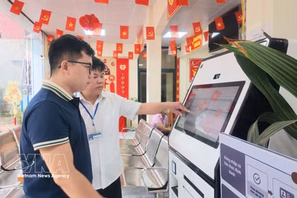 Des agents du Centre de services administratifs publics de la commune de Chi Lang, dans la province de Lang Son, guident les habitants dans l'utilisation du KIOSK de services publics assisté par l'intelligence artificielle (IA). Photo : VNA