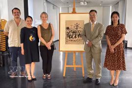 L’ambassadeur vietnamien Trinh Duc Hai (2e de droite) et la directrice du Musée d’Art et d’Histoire Paul Éluard, Valérie Perlès (3e de droite) à côté de l’œuvre originale "Vive la Paix", réalisée par le peintre Pablo Picasso. Photo: VNA