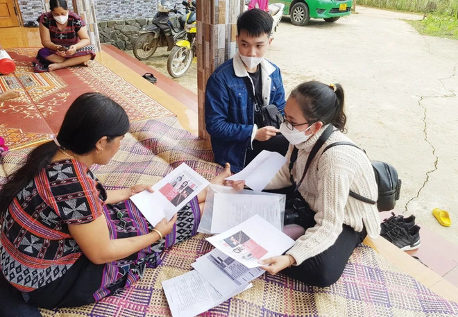 Un membre du CPED présente des motifs de textile à une femme dans la commune de Lam Dot, district d'A Luoi, province de Thua Thien-Hue. Photo: Vietnamplus 2.png