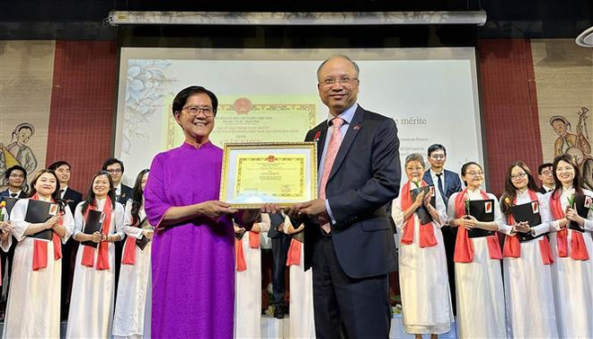 Remise du certificat de mérite de l’ambassadeur du Vietnam en France à une représentante de la chorale « Hop ca Que huong ». Photo: VNA vna_potal_le_ky_niem_15_nam_thanh_lap_cua_nhom_hop_xuong_hop_ca_que_huong_tai_phap_7422464.jpg