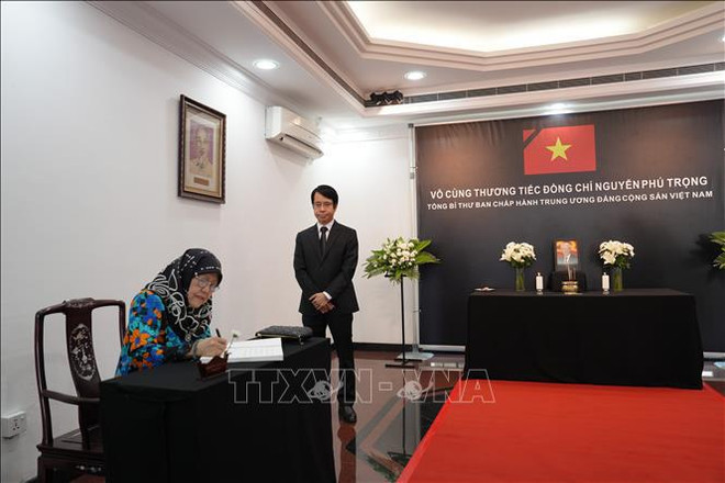 La princesse Hajah Masna écrit dans le registre de condoléances. Photo: VNA 2.jpg