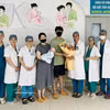 Le personnel médical de l'hôpital offre des fleurs au couple et à leur bébé pour les féliciter de leur sortie de l'hôpital. Photo : VNA