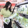 Une cliente choisit des légumes cultivés en hydroponie dans un supermarché. Photo : VNA