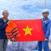 Remise d'un drapeau national à des pêcheurs. Photo : VNA