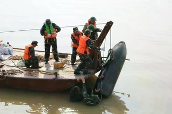 Les forces militaires de la province de Nghe An (Centre) et la bombe de 226 kg datant de la guerre. Photo: VNA