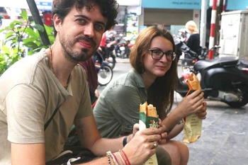 Des touristes dégustent du « bánh mì ». Photo: VNA
