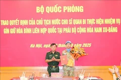 Le général de corps d'armée Hoàng Xuân Chiên, vice-ministre de la Défense remet la décision du président de la République au commandant Lê Vinh Hoàng, nommé pour participer à la mission de maintien de la paix des Nations Unies au Soudan du Sud. Photo: VNA