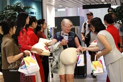 Offre des cadeaux aux passagers venus de Manille (Philippines) et de Bali (Indonésie). Photo: VNA