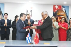 Le ministre vietnamien de la Justice, Nguyen Hai Ninh (gauche) et son homologue cubain, Oscar Manuel Silvera Martínez, signent un accord portant sur un projet d'assistance technique destiné au ministère cubain de la Justice. Photo: VNA