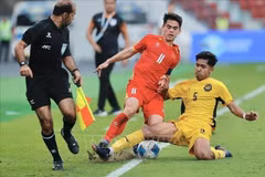 Un joueur malaisien U22 tente de bloquer le dribble de Khuat Van Khang. Photo : VNA 
