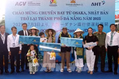Lors de la cérémonie d'accueil, le comité d'organisation a offert des fleurs et des cadeaux à trois heureux invités du vol VN337 Osaka-Da Nang. Photo : VNA