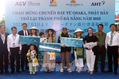 Lors de la cérémonie d'accueil, le comité d'organisation a offert des fleurs et des cadeaux à trois heureux invités du vol VN337 Osaka-Da Nang. Photo : VNA