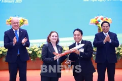 L'ambassadrice de Nouvelle-Zélande au Vietnam, Caroline Beresford, remet le certificat d'ouverture de la nouvelle ligne aérienne direct reliant Ho Chi Minh-Ville à Auckland au vice-président du conseil d'administration de Vietjet, Nguyen Anh Tuan, en présence des Premiers ministres du Vietnam et de la Nouvelle-Zélande. Photo : VNA