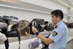 Tran Viet Hung, chef du service professionnel de l'Agence de surveillance et de développement du marché intérieur relevant du ministère de l'Industrie et du Commerce, vérifie les marchandises. Photo : Ministère de l’Industrie et du Commerce