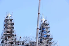 Deux croix ont été installées avec succès au sommet des deux tours de Cathédrale Notre-Dame de Saïgon, à une hauteur d’environ 60 mètres. Photo : VNA