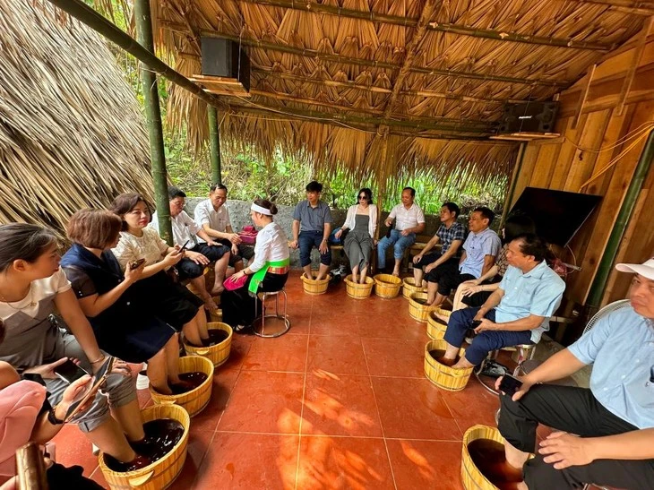 Des touristes expérimentant un bain de pieds thérapeutiques. Photo: Hoàng Quyên