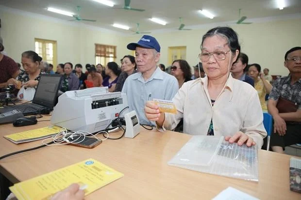 Paiement de la pension pour des personnes âgées. Photo: Vietnamplus