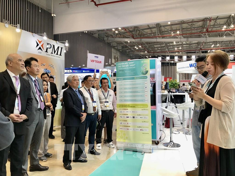 Une entreprise présente des informations aux visiteurs lors de l'exposition. Photo: VNA