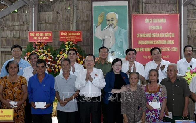 Le président de l'Assemblée nationale, Tran Thanh Man, offre des cadeaux à des familles bénéficiaires de politiques sociales et des personnes ayant rendu des services méritoires à la Révolution. Photo: VNA