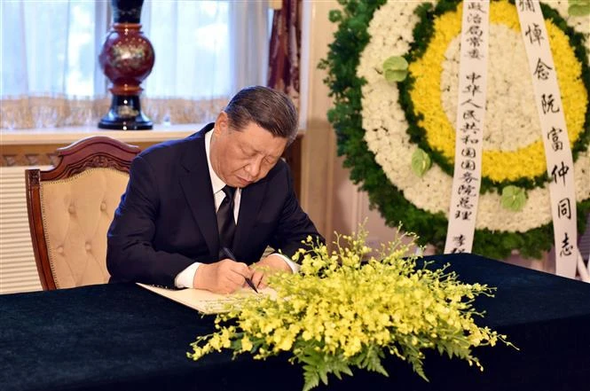 Le secrétaire général et président chinois Xi Jinping écrit dans le registre de condoléances. Photo : VNA