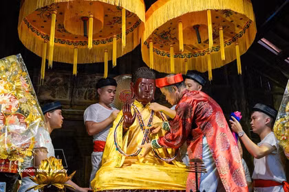 Exécution du rituel de l''habillage du Bouddha", l'un des rites uniques et rares encore préservés à la fête du village Keo. Photo: VNA