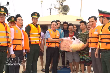 Le vice-président du Comité populaire de la ville de Hai Phong, Tran Van Quan, remet des cadeaux à des pêcheurs étrangers ayant été secourus par les forces vietnmiennes. Photo: VNA