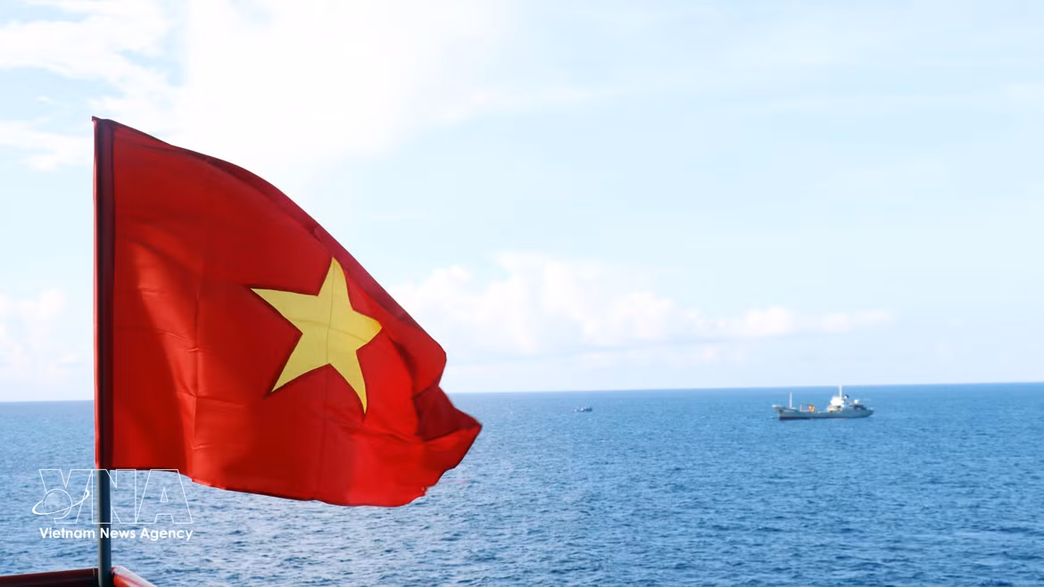 Le drapeau national flotte au cœur du ciel et de la mer de la Patrie