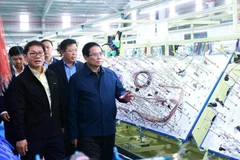 Le Premier ministre Pham Minh Chinh visite une chaîne de production d'une entreprise à Quang Nam. Photo: VNA