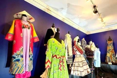 L’ao dai Nhât Binh et des costumes d'autres pays lors de l'exposition. Photo: VNA