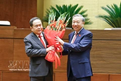 Le secrétaire général du Parti, Tô Lâm, offre un bouquet de fleurs pour féliciter le Président de l'Assemblée nationale, Trân Thanh Mân. Photo : VNA