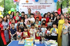 L'ambassadeur du Vietnam en Malaisie Dinh Ngoc Linh et les élèves. Photo: VNA