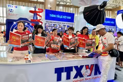 Des visiteurs découvrent le stand de l’Agence vietnamienne d’information à l’Exposition des réalisations nationales. Photo: VNA