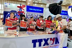 Des visiteurs découvrent le stand de l’Agence vietnamienne d’information à l’Exposition des réalisations nationales. Photo: VNA
