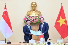 Le ministre de l’Industrie et du Commerce, Nguyên Hông Diên (gauche), et Tan See Leng, ministre chargé de l’Énergie ainsi que des Sciences et Technologies au sein du ministère du Commerce et de l’Industrie (MTI) de Singapour. Photo: nhandan.vn