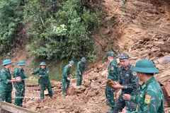 Des officiers et soldats du poste-frontière de Chieng On dégagent une route après un glissement de terrain. Photo : VNA