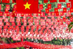 Le rouge éclatant du drapeau national inonde la rue de Hang Ma, quartier de Hoan Kiêm à Hanoi. Photo: VNA