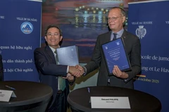 Le vice-président du Comité populaire de la ville de Da Nang, Trân Nam Hung (gauche), et le maire de la ville du Havre, Édouard Philippe, signent un Protocole d'Entente instaurant une relation de coopération et d'amitié entre ces deux cités portuaires, l'une au Vietnam, l'autre en France. Photo: VNA