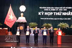 Trân Luu Quang (2e à partir de la droite), membre du Bureau politique et secrétaire du Comité du Parti de Hô Chi Minh-Ville, et Nguyên Duc Hai (3e à partir de la gauche), vice-président de l'Assemblée nationale, remettent les décisions de reconnaissance aux membres du Conseil populaire municipal. Photo: VNA