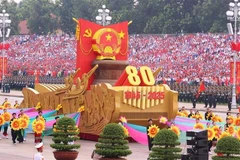 Un véhicule miniature portant l'emblème national de la République socialiste du Vietnam mène le défilé militaire et le cortège de masse. Photo : VNA