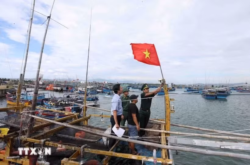 Des gardes-frontières inspectent le dispositif de surveillance d'un bateau de pêche avant qu'il ne prenne le large. Photo : VNA