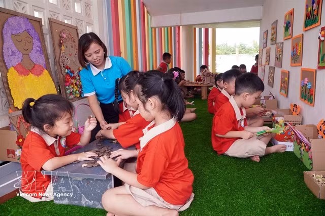 Une enseignante et des enfants du jardin d'enfants Tran Cao de la commune de Quang Hưng, province de Hung Yên, participent à des activités d'apprentissage expérientiel. Photo : VNA