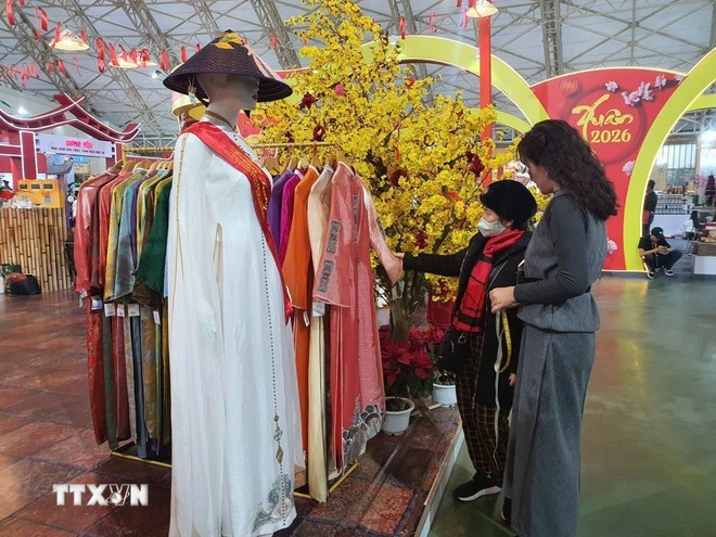 Les stands présentant l'ao dai de Hue (robe traditionnelle vietnamienne) comme un produit culturel distinctif ont suscité un vif intérêt auprès du public. Photo : VNA