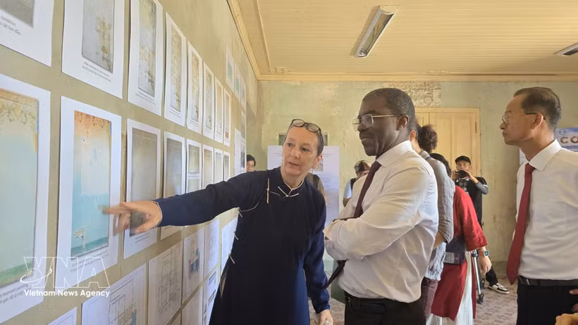 Mme Andrea Teufel, représentante principale de la Société allemande pour la préservation du patrimoine culturel au Vietnam, présente la restauration des peintures murales à M. Lazare Eloundou, directeur du Centre du patrimoine mondial de l'UNESCO. (Photo : VNA)