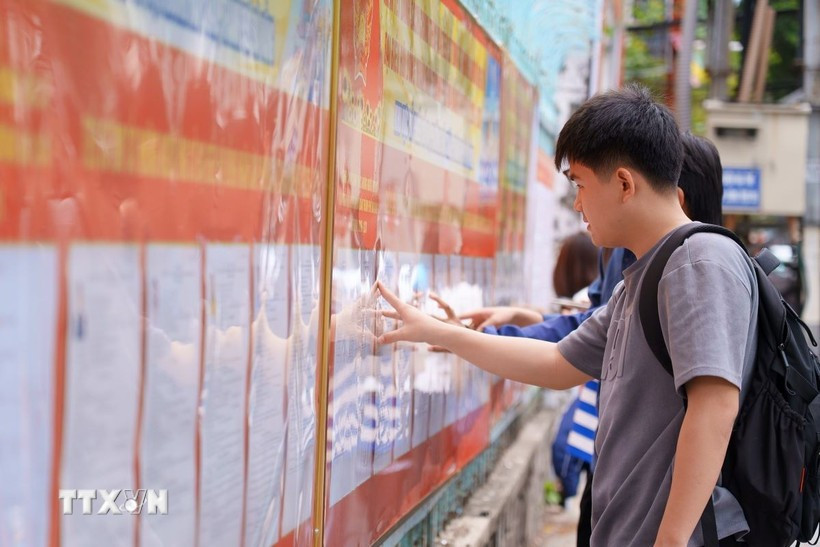 Des étudiants de Université pédagogique et technique – Université de Da Nang consultent la liste des candidats affichée au sein de l’établissement. Photo : VNA.
