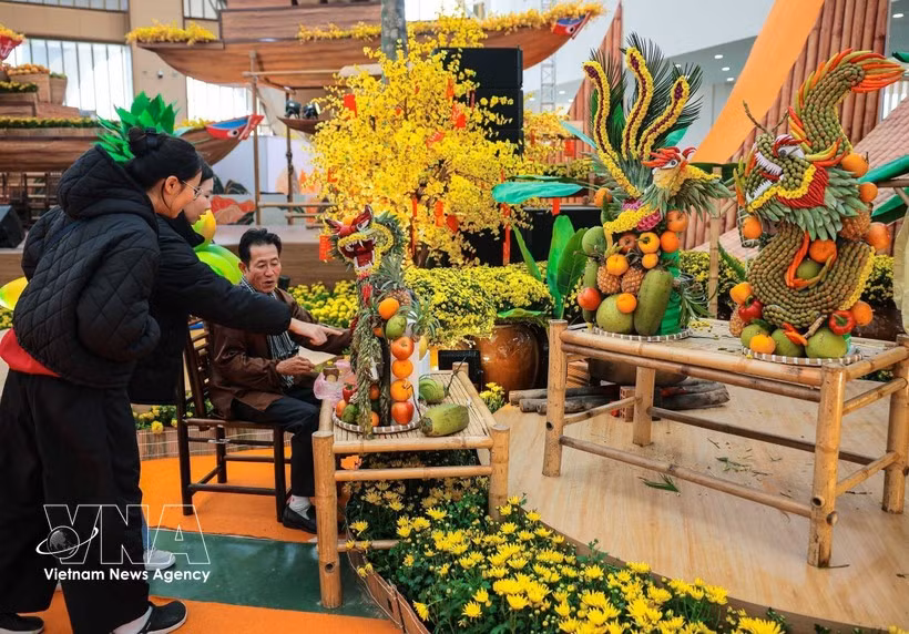 De nombreux visiteurs admirent les créations artistiques à base de fruits réalisées par l'artisan Nguyen Van Tuyen, originaire d'Hô Chi Minh-Ville. (Photo : VNA)